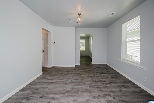 spare room with dark hardwood / wood-style flooring and a wealth of natural light