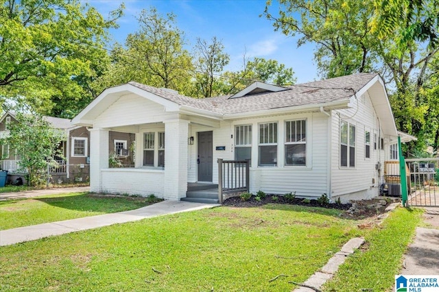 view of front of property featuring central AC, a front lawn, and covered porch