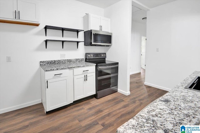 kitchen with white cabinets, light stone counters, appliances with stainless steel finishes, and dark hardwood / wood-style flooring