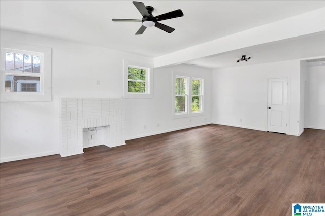 unfurnished living room featuring a brick fireplace, ceiling fan, and dark hardwood / wood-style floors