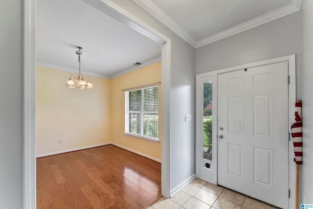 foyer entrance featuring light wood-type flooring, crown molding, and a chandelier