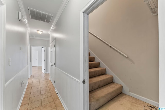 corridor featuring crown molding and light tile patterned floors