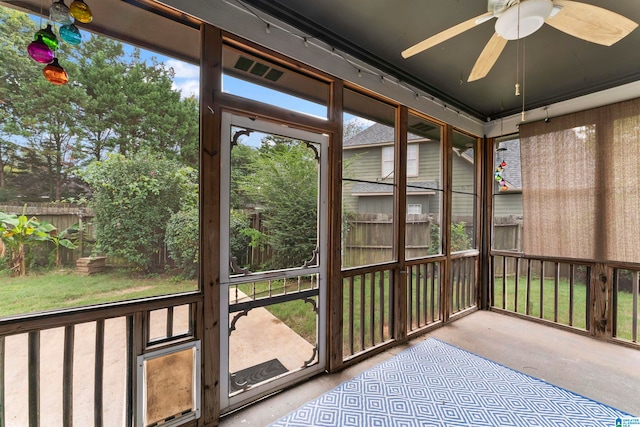 unfurnished sunroom with ceiling fan