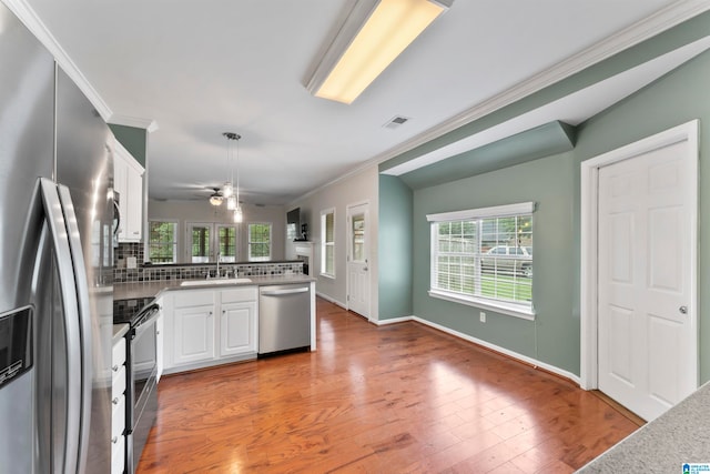 kitchen with ceiling fan, white cabinets, sink, backsplash, and appliances with stainless steel finishes