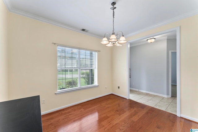 unfurnished room with an inviting chandelier, light hardwood / wood-style floors, and crown molding