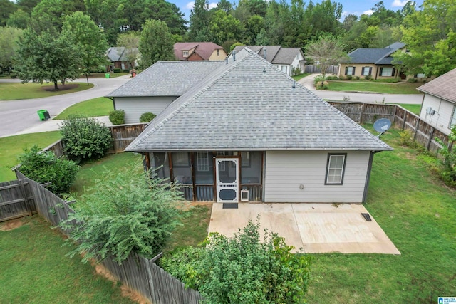 rear view of property featuring a lawn and a sunroom