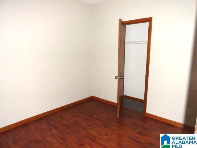 unfurnished bedroom with dark wood-type flooring