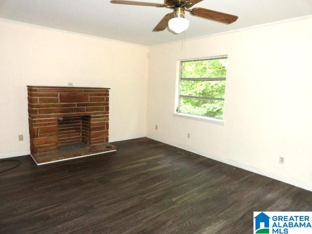 unfurnished living room featuring ceiling fan, dark hardwood / wood-style floors, and ornamental molding