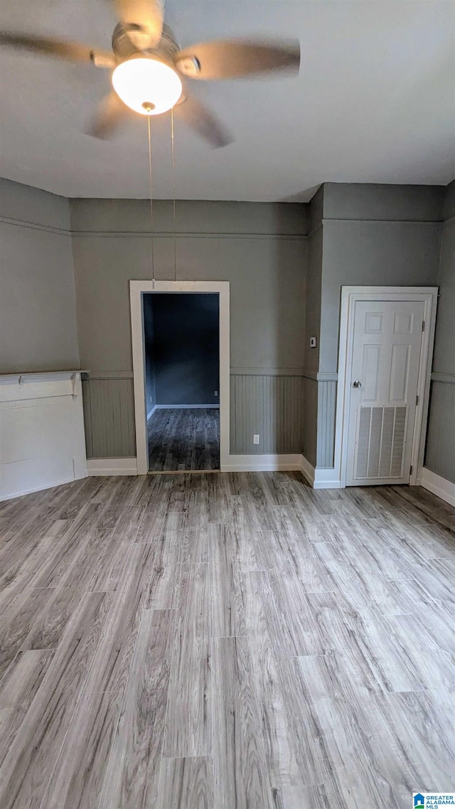 unfurnished living room featuring light hardwood / wood-style flooring and ceiling fan