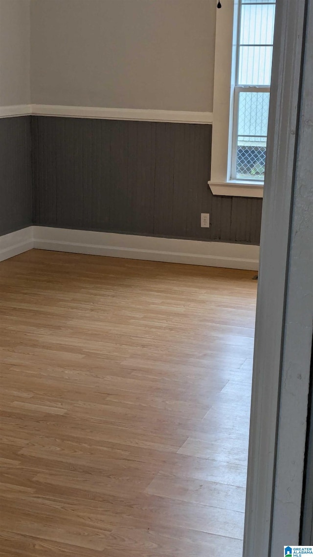 empty room featuring light hardwood / wood-style flooring and wood walls