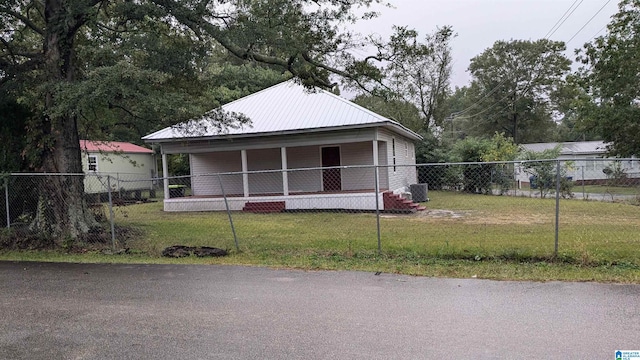 view of front of property featuring a porch, a front lawn, and central air condition unit