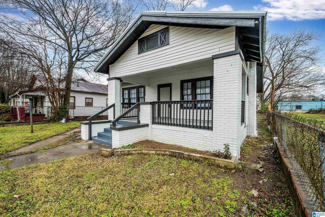 bungalow featuring a front lawn and covered porch