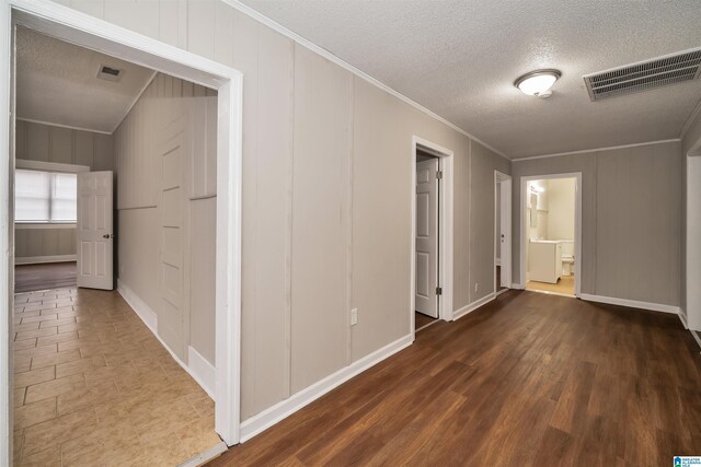 hallway featuring a textured ceiling, crown molding, and dark hardwood / wood-style floors