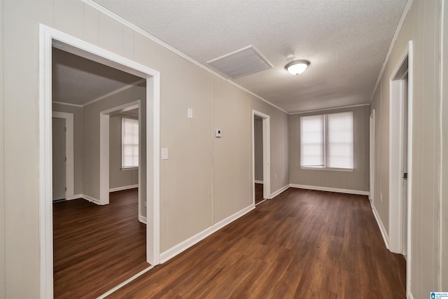 hallway with a textured ceiling, dark hardwood / wood-style floors, and crown molding