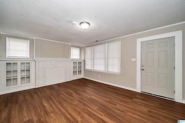 foyer with a textured ceiling, plenty of natural light, a fireplace, and dark hardwood / wood-style flooring