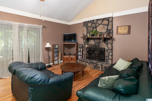 living room featuring high vaulted ceiling, hardwood / wood-style flooring, and a stone fireplace