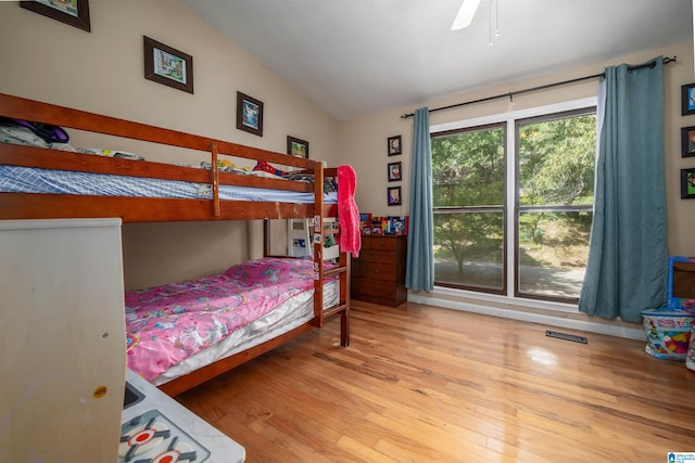 bedroom with light hardwood / wood-style flooring, lofted ceiling, and ceiling fan