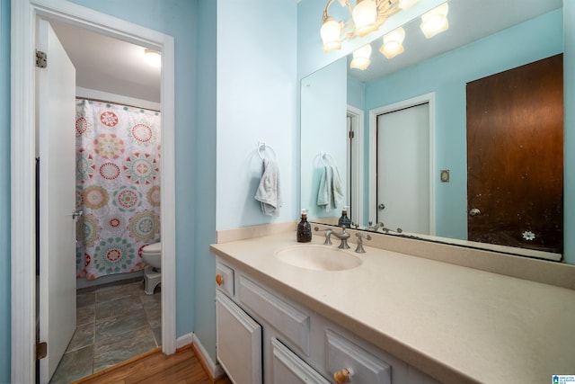 bathroom with wood-type flooring, vanity, and toilet