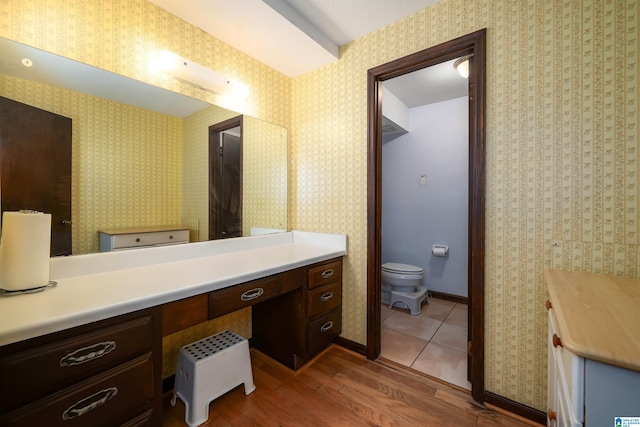 bathroom featuring wood-type flooring, vanity, and toilet