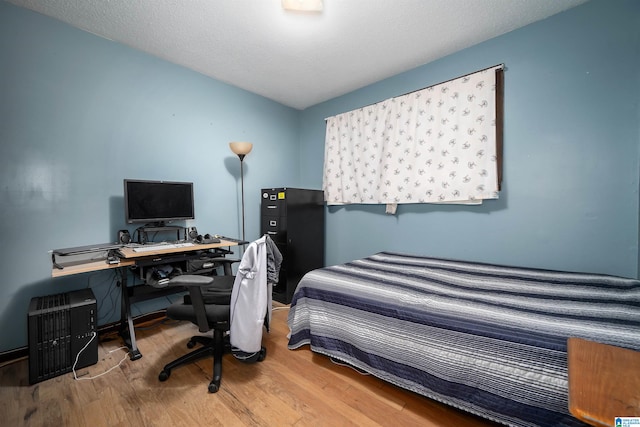 bedroom featuring a textured ceiling and hardwood / wood-style flooring