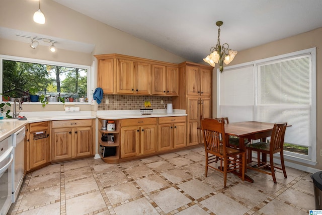 kitchen featuring pendant lighting, a notable chandelier, backsplash, and vaulted ceiling