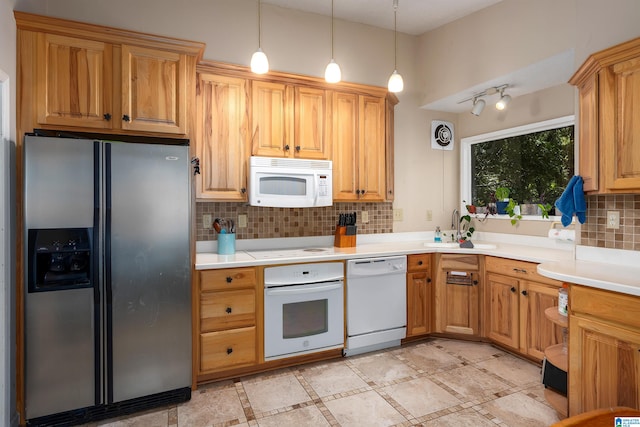 kitchen with decorative backsplash, white appliances, hanging light fixtures, and sink