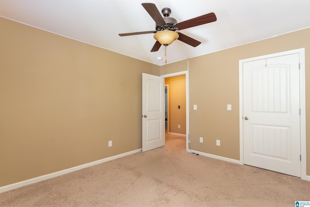 unfurnished bedroom featuring a closet, ceiling fan, and light colored carpet