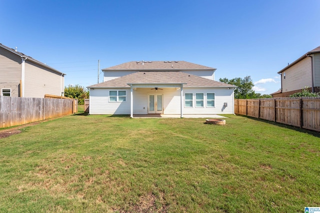 rear view of property with a patio, ceiling fan, and a yard