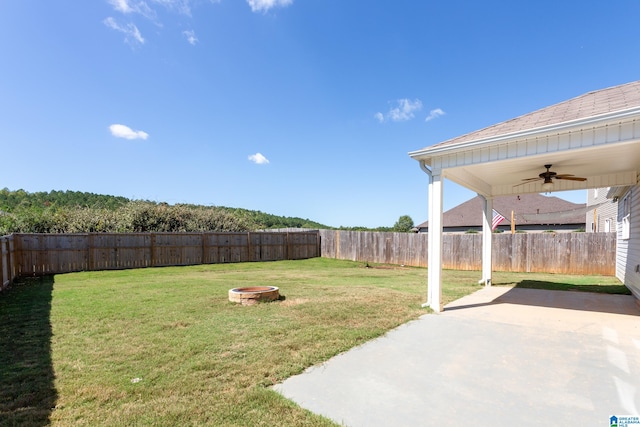 view of yard featuring a patio, ceiling fan, and an outdoor fire pit