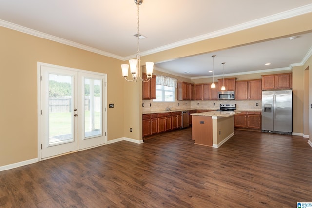 kitchen featuring dark wood-type flooring, a kitchen island, an inviting chandelier, appliances with stainless steel finishes, and decorative light fixtures