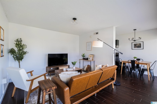 living room with a chandelier and dark wood-type flooring