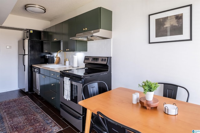 kitchen featuring appliances with stainless steel finishes, dark tile patterned flooring, tasteful backsplash, a textured ceiling, and sink