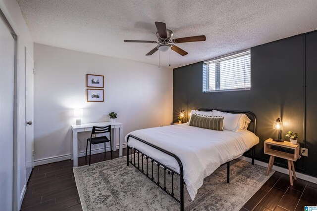 bedroom with a textured ceiling, dark hardwood / wood-style flooring, and ceiling fan