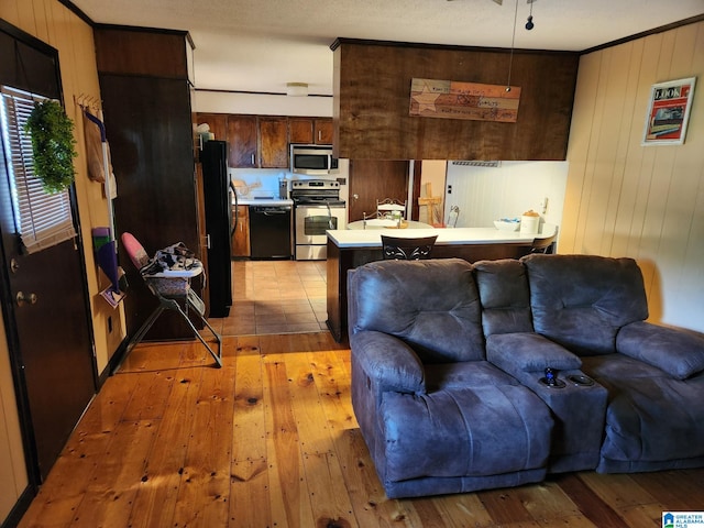 living room with light wood-type flooring and wood walls