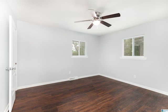 empty room with ceiling fan and dark hardwood / wood-style flooring