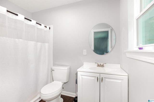 bathroom with a shower with shower curtain, hardwood / wood-style floors, vanity, and toilet