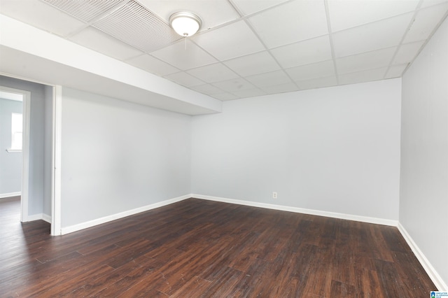 interior space with a paneled ceiling and dark hardwood / wood-style flooring