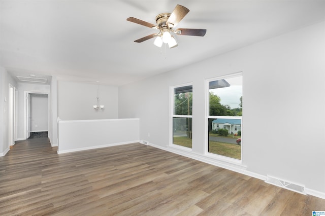 interior space with ceiling fan with notable chandelier and wood-type flooring