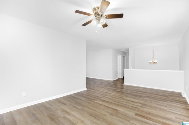 interior space with wood-type flooring and ceiling fan with notable chandelier