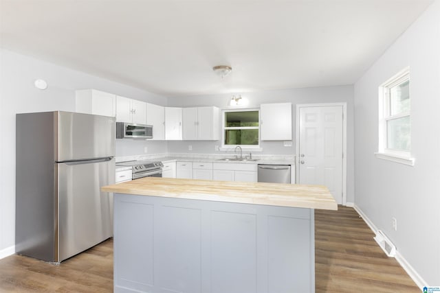 kitchen featuring a center island, stainless steel appliances, and white cabinets