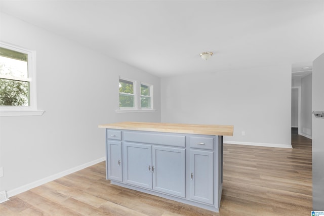 kitchen with light wood-type flooring, gray cabinetry, and wooden counters