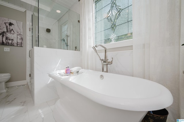 bathroom featuring separate shower and tub and toilet