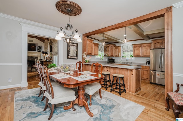 477 Seales Rd, Helena, AL 35022 - dining room with light wood-type flooring, a fireplace, a notable chandelier, and baseboards