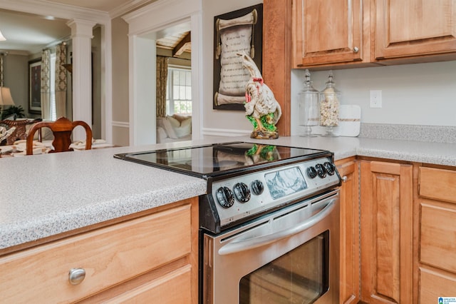 kitchen with stainless steel range with electric cooktop, decorative columns, and ornamental molding