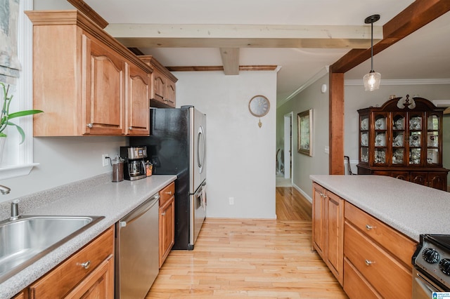 kitchen featuring appliances with stainless steel finishes, crown molding, light wood-type flooring, and pendant lighting