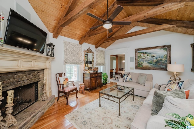 living room with lofted ceiling with beams, a fireplace, light hardwood / wood-style flooring, ceiling fan, and wooden ceiling