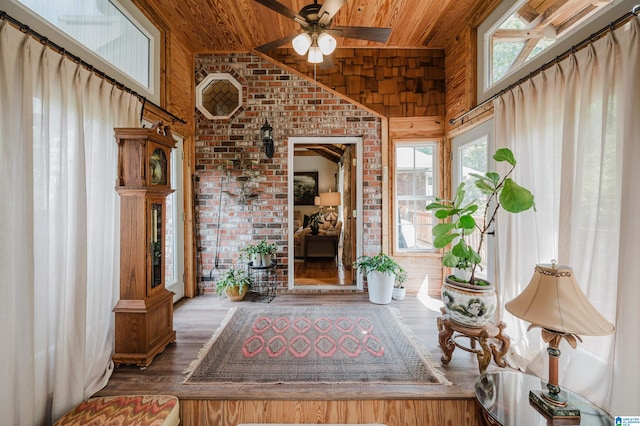 interior space featuring wood ceiling, ceiling fan, brick wall, and hardwood / wood-style flooring