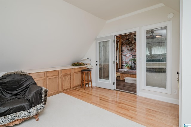 sitting room with light wood-type flooring and vaulted ceiling