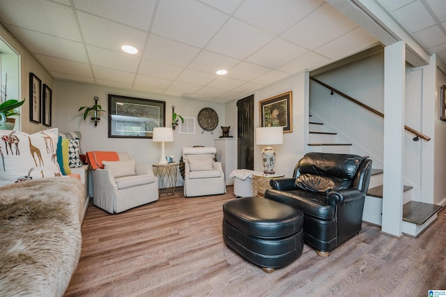 living room featuring wood-type flooring and a paneled ceiling