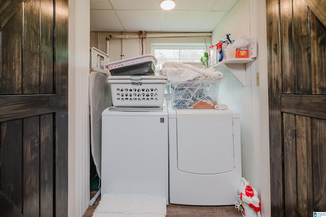 washroom featuring wooden walls and separate washer and dryer